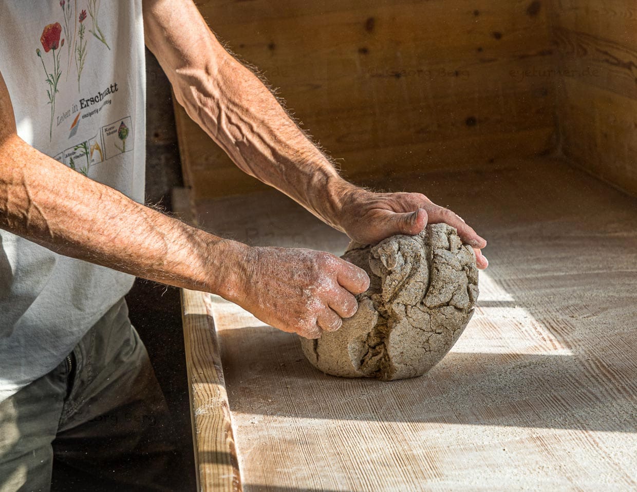 Bevor die Teilnehmer des Workshops selber Hand anlegen, zeigt Edmund Steiner wie man die Schrunde und Spalten aus dem Roggenteig arbeitet / © Foto: Georg Berg