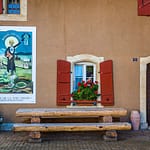 Absinth in Frankreich und der Schweiz. In Motiers im Schweizer Kanton Neuchâtel befindet sich das unterhaltsame Absinthmuseum, und an einigen Häuserwänden der Stadt erinnern historische Plakate an die Zeit der Prohibition / © Foto: Georg Berg