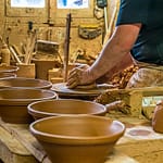 Cassole ist die irdene Keramikform, in der das Cassoulet zubereitet wird. Cassoulet ist ein Gemeinschaftsessen. Beliebt ist die Größe für 8 Personen. Das Formen einer Cassole dauert rund 10 Minuten. Griffe werden angesetzt und der Firmenstempel plaziert. / © Foto: Georg Berg