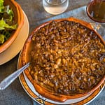 Chef Eric Rousselot bereitet das berühmte Cassoulet Imperial in der Hostellerie Etienne zu, die seit 1956 als Familienbetrieb geführt wird. Die braune Kruste gehört zu einem guten Cassoulet. Des weiteren nur noch ein einfacher Salat und ein Glas Wein - c’est tout - c’est bien! / © Foto: Georg Berg