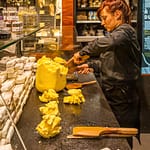 Im Maison du Beurre in Saint Malo teilt die Verkäuferin aus einem Butterblock Stücke von 125 g ab / © Foto: Georg Berg