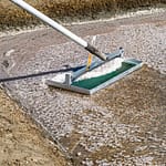 Die Salzflocken werden vorsichtig von der Wasseroberfläche geschöpft. Dabei darf das Werkzeug im flachen Becken nicht mit dem Lehmboden in Berührung kommen / © Foto: Georg Berg