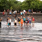 Kinder winken am Strand im ländlichen Indonesien / © Foto: Georg Berg