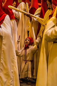 Mitglieder der der Hermanidad de San Pedro Apóstol und ein Kind in spanischer Prozession mit Kerzenträgerinnen / © Foto: Georg Berg