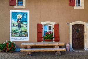Absinth in Frankreich und der Schweiz. In Motiers im Schweizer Kanton Neuchâtel befindet sich das unterhaltsame Absinthmuseum, und an einigen Häuserwänden der Stadt erinnern historische Plakate an die Zeit der Prohibition / © Foto: Georg Berg