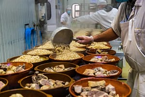 Industrielle Herstellung des Cassoulets von Castelnaudary. In Castelnaudary gibt es mehrere Fabriken, die für ganz Frankreich Cassoulet in Dosen herstellen. Bei Escourrou kann der Eintopf auch in der traditionellen Cassole gekauft werden. / © Foto: Georg Berg