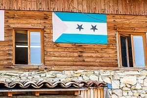 Die Flagge von São Tomé & Príncipe hängt am Gebäude der Schokoladenfabrik Frigoulette. Der Inselstaat im Golf von Guinea trägt auch den Namen Schokoladeninsel. 1822 ließen sich portugiesischen Siedler aus Brasilien auf São Tomé & Principe nieder. Sie brachten auch Kakaopflanzen mit.  Der Boden vulkanischen Ursprungs und die günstigen klimatischen Bedingungen ermöglichten eine rasche Entwicklung des Kakaoanbaus, der 1913 mit 36.000 Tonnen seinen Höhepunkt erreichte. Heute produziert die Insel nur rund 3.000 Tonnen und eine umweltfreundliche und nachhaltige Steigerung der Produktivität ist Firmengründer Bernard Xueref ein wichtiges Anliegen / © Foto: Georg Berg