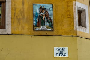 Gemaltes Bild des Herablassens Jesu Christi an einer spanischen Hauswand mit Straßenname / © Foto: Georg Berg