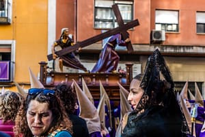 Die Hermandad de Nuestro Padre Jesús Caído y La Verónica trägt den gleichnamigen Paso. Es wird die Szene dargestellt, in der Jesus auf dem Weg zur Kreuzigung unter der Last des Kreuzes zusammenbricht und die heilige Veronika ihm das Schweißtuch reicht. Die trauernden Frauen mit Schleier und Mantilla (Manolas) zeigen die Verbindung zwischen dem biblischen Geschehen und dem heutigen Leben: Sie bringen das Mitgefühl und die Anteilnahme der Gemeinschaft zum Ausdruck und schaffen eine Brücke zwischen religiöser Tradition und persönlicher Erfahrung von Trauer und Hoffnung / © Foto: Georg Berg