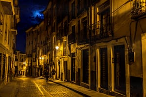 Eine Straße in Cuenca mit Gebäuden und Fußgängern in der Karfreitagsnacht bei Mondschein / © Foto: Georg Berg