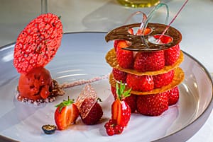 Dessert aus Mara des Bois Erdbeeren. Ein dreigeschossiges Erdbeerdessert mit Etagenböden aus Krokant-Chips und einem Erdbeer-Sorbet auf Rhabarber-Vervene-Mousse verziert mit einem Erdbeer-Algen Chips mag man gar nicht mit seinem Löffel unterwandern, so schön ist es anzusehen / © Foto: Georg Berg
