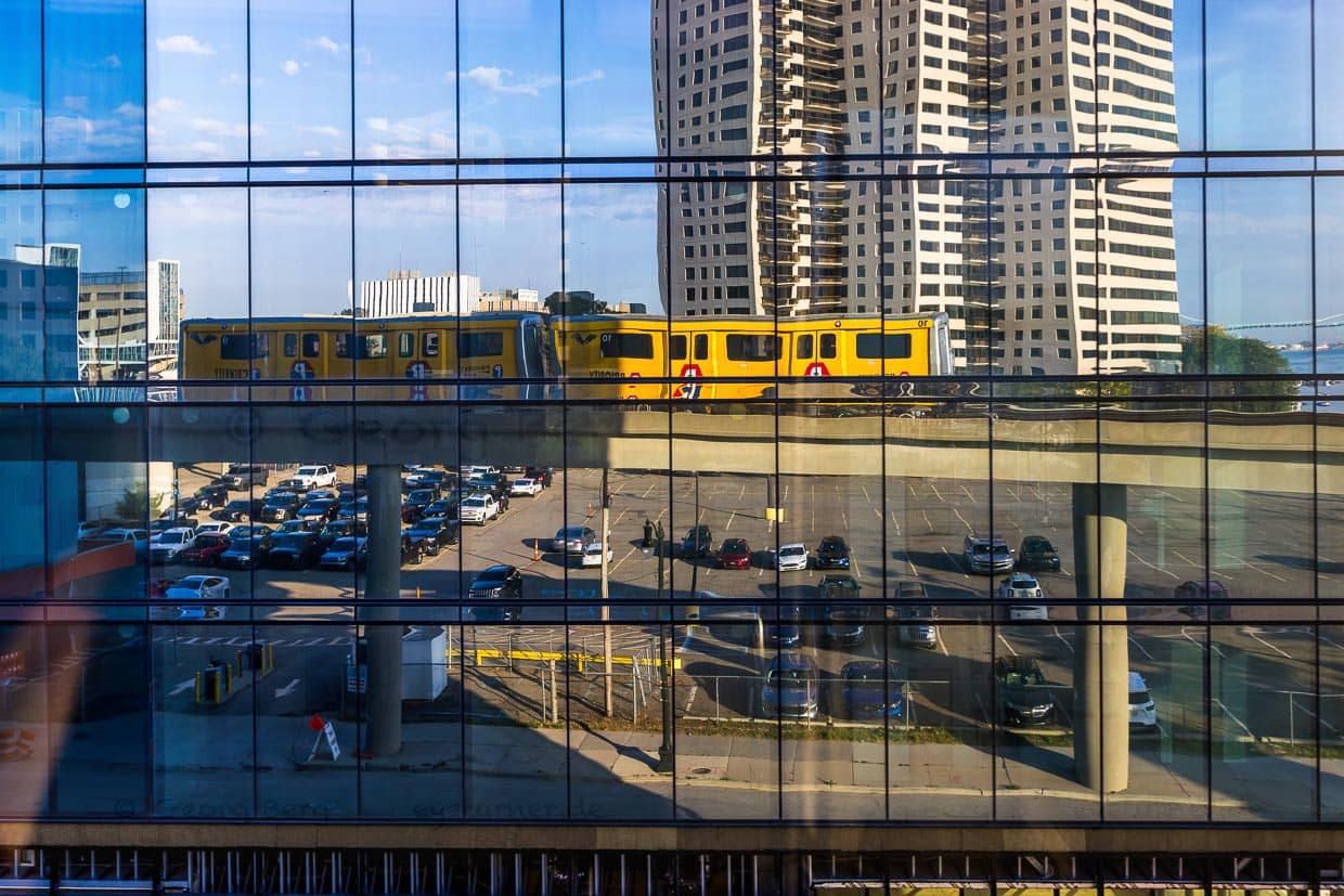 Spiegelung des Detroit People Mover. Es ist ein 4,7 Kilometer langes, automatisch betriebenes Hochbahnsystem durch die Innenstadt von Detroit. Fahrgäste der Ringlinie sind Touristen und Arbeitnehmer aus den Geschäften und Büros der Innenstadt. Die Fahrt kostet einen Vierteldollar (Quarter) und bietet einen interessanten Blick auf die Gebäude in Downtown Detroit / © Foto: Georg Berg