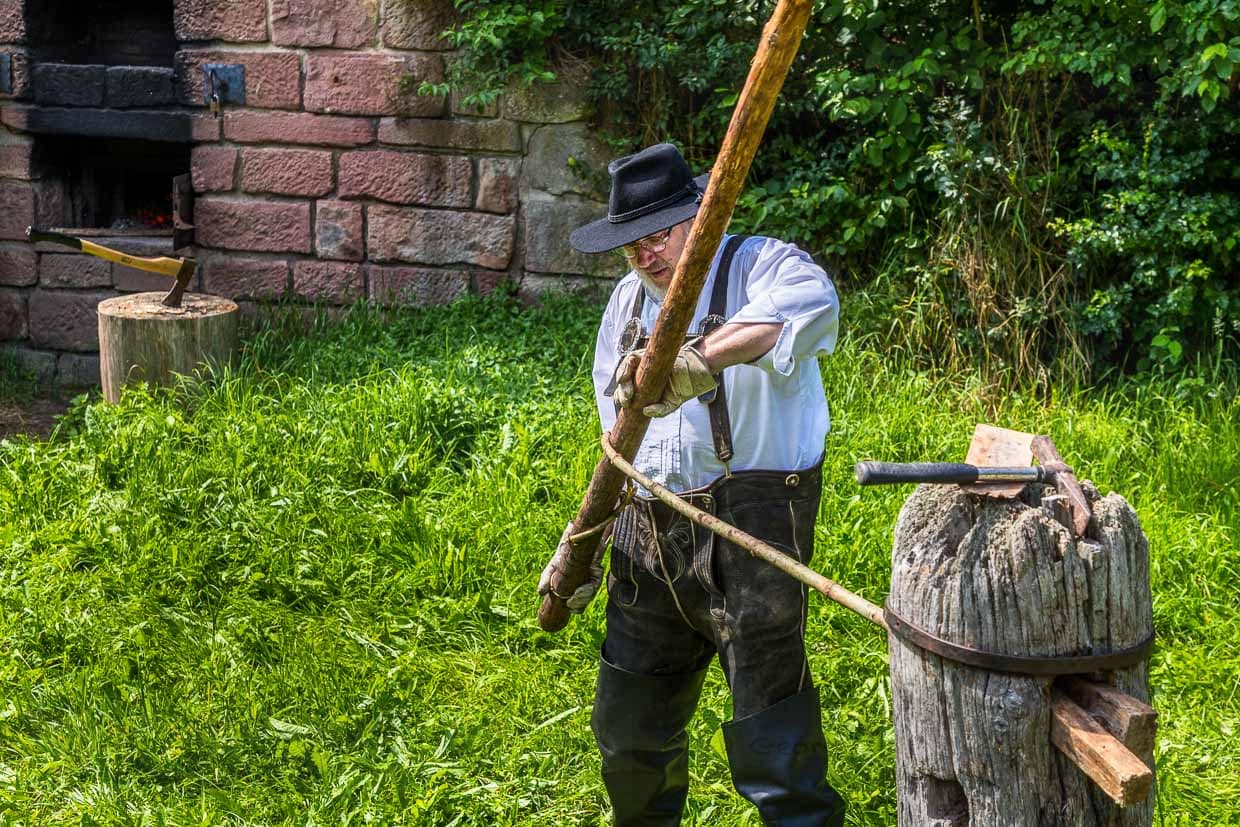 Das heiße Tannenstämmchen ist in einem sogenannten Wiedstock eingespannt. Dort wird es mit einer Drehstange gedreht, wodurch sich die Holzfasern voneinander lösen und eine Art Holzseil entsteht / © Foto: Georg Berg