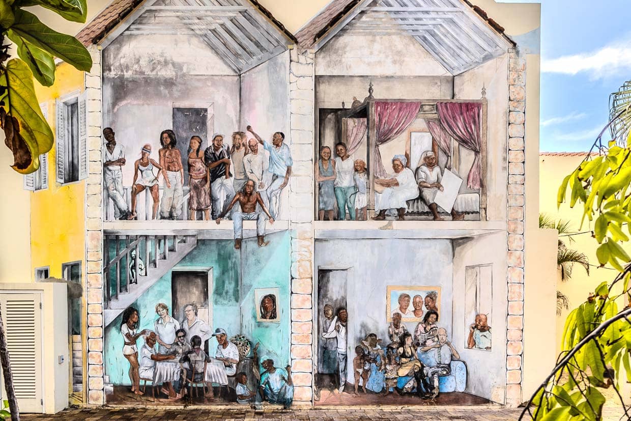En una pared de la capital de Curaçao, una pintura personalizada muestra cuatro escenas típicas de la sociedad urbana de la época en que Willemstadt fue declarada Patrimonio de la Humanidad por la UNESCO / © Photo: Georg Berg