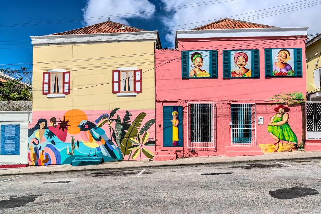 La artista colombiana Viviana Grondona y Merly Trappenberg de Curaçao en fachadas de casas vecinas en Otrabanda. Merly Trappenberg es conocida por sus retratos de mujeres voluptuosas / © Foto: Georg Berg