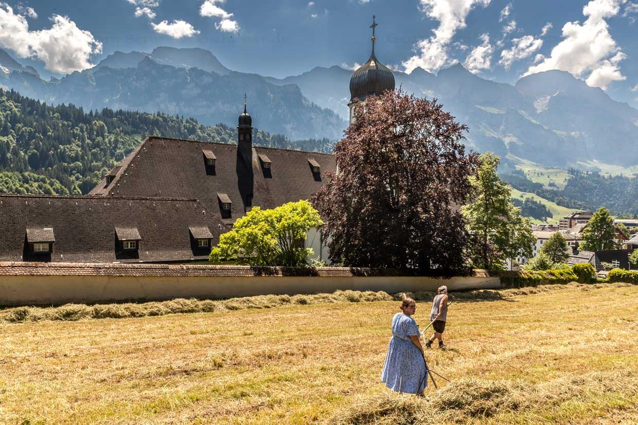 Sommer in Engelberg: Frauen wenden Heu vor den Mauern des Benediktiner Klosters Engelberg / © Foto: Georg Berg