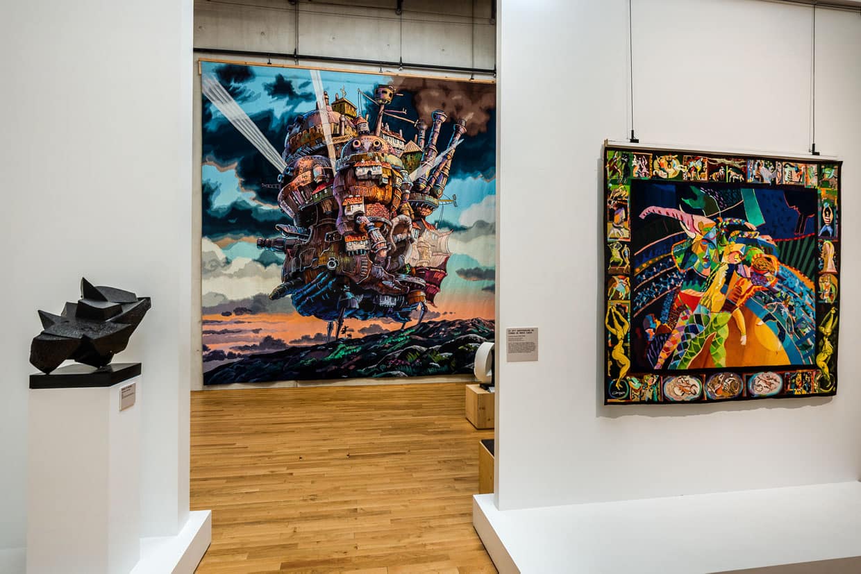 Gewebte Abenteuer in den Ausstellungsräumen der Cité internationale de la tapisserie Aubusson. Hier „The moving castle at sunset“ aus dem Animefilm von 2004 Howl’s Moving Castle. Gewebt in Aubusson ab März 2022 bis Februar 2023 / © Foto: Georg Berg